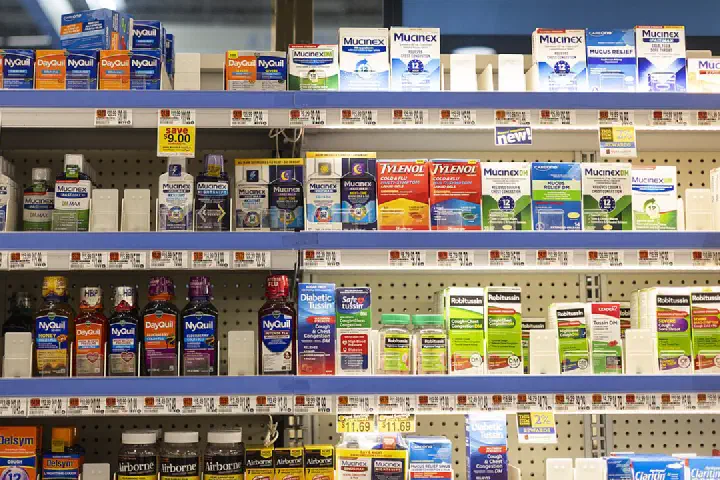 Various medications in an aisle of a grocery store's pharmacy section.