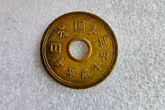 The reverse of a Japanese 5-yen coin.
