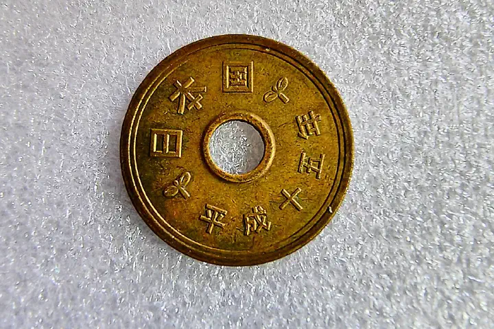 The reverse of a Japanese 5-yen coin.