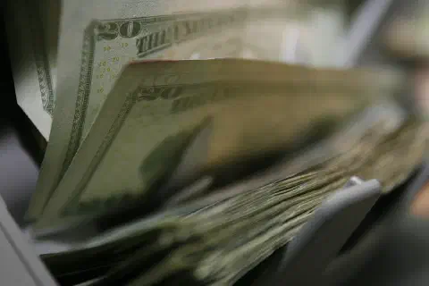 Twenty-dollar bills are counted and packaged for future missions at the Camp Taqaddum disbursing office, June 29, 2006.