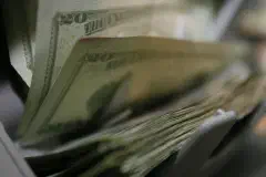 Twenty-dollar bills are counted and packaged for future missions at the Camp Taqaddum Disbursing office June 29, 2006
