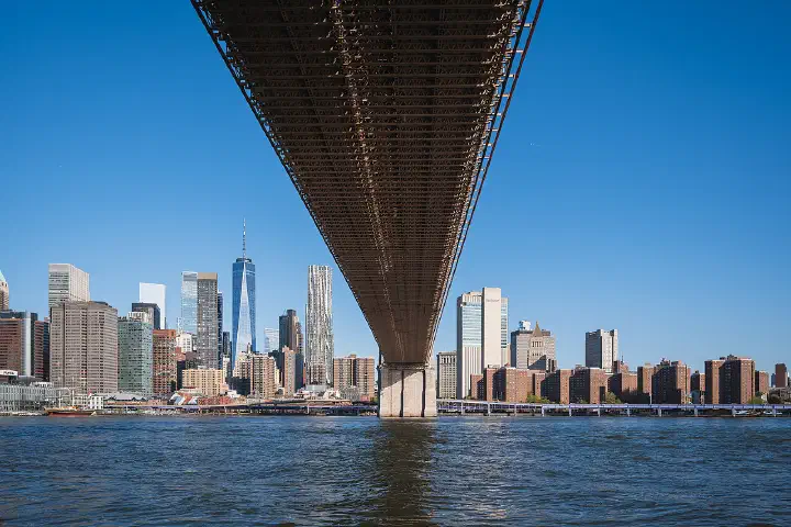 The Lower Manhattan skyline seen from beneath the deck of the Brooklyn Bridge, New York City.