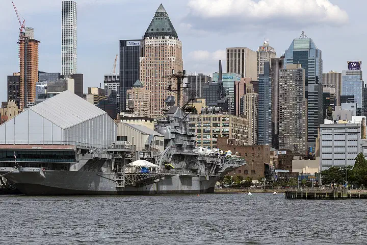 The Intrepid Sea Air Space Museum and the West Side skyline of Manhattan from the Hudson River, New York.