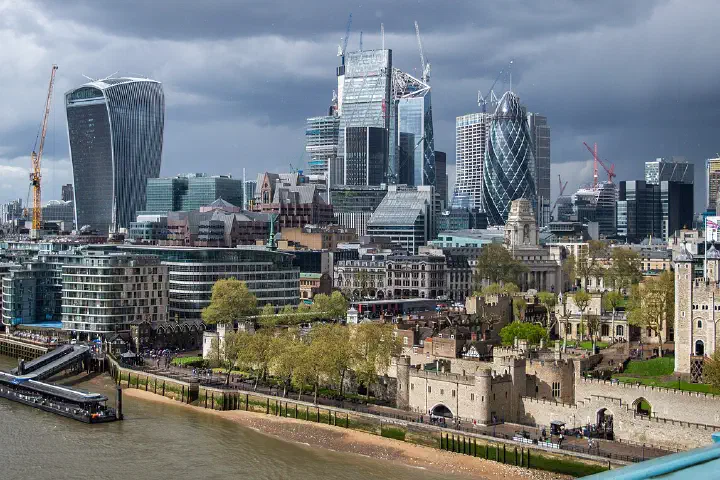 High-rise buildings of the City of London together with part of the Tower of London, seen from the west walkway of Tower Bridge.