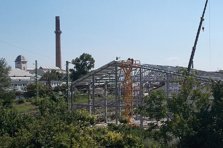 Deployed truck-mounted crane and scissor lift at Credobus bus factory construction
