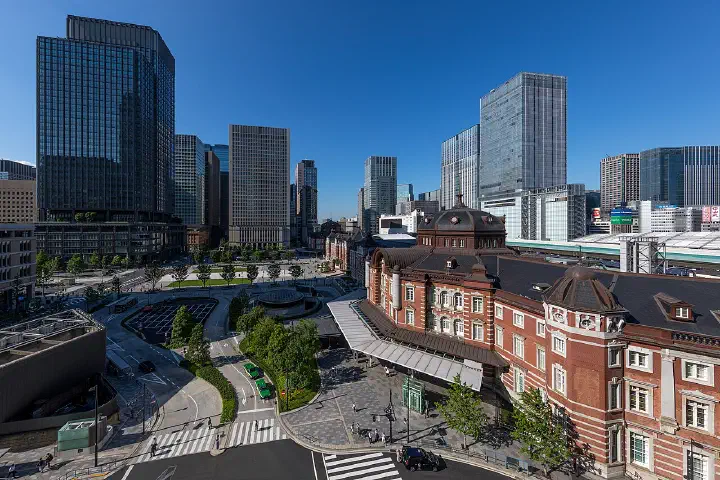 Marunouchi Central Plaza, with the red-brick Tokyo Station and the Shin-Marunouchi Building at left, on a sunny afternoon.