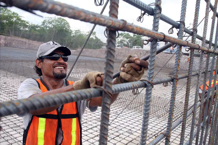 A worker assembling rebar at a construction site.