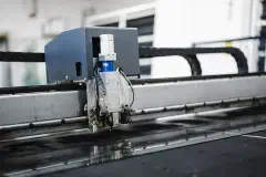 A machine cutting material on a factory production line