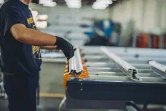 A worker assembling metal parts on a factory production line