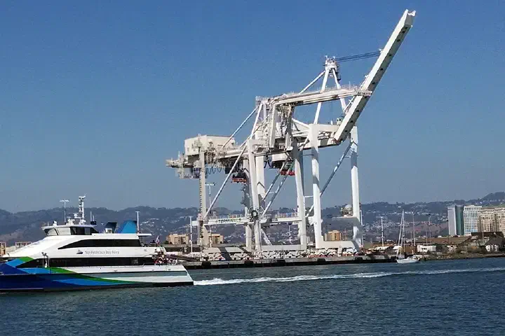 The Scorpio passes port cranes in the Oakland Estuary, September 2014.