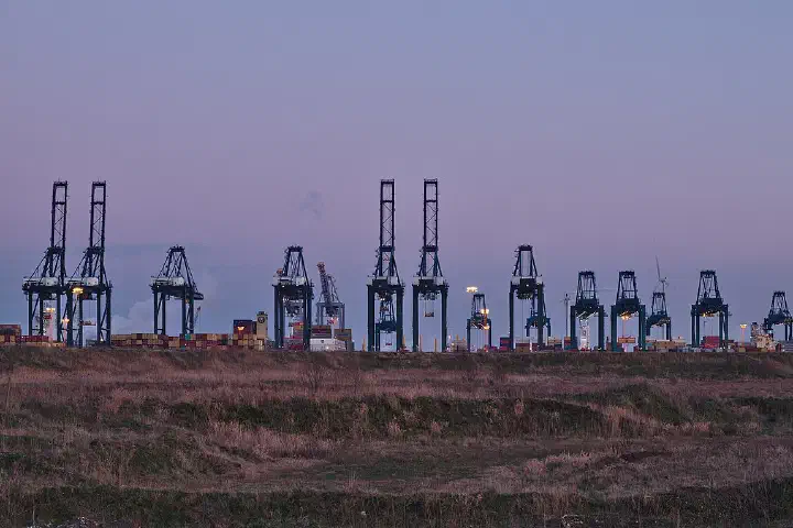 Container cranes at the MSC PSA European Terminal in the Port of Antwerp at dusk.