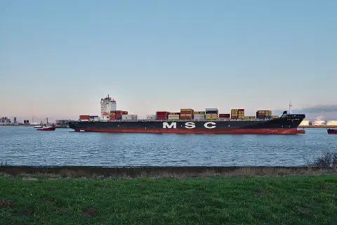 The container ship MSC Carmen is towed along the Scheldt toward the Port of Antwerp, seen from Doel, Belgium.
