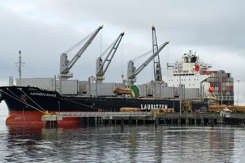 The Lauritzen bulk carrier Happiness Bulker loading raw logs at the dock in Port Angeles Harbor, Washington.